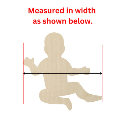 a wooden cutout of a baby sitting on the ground